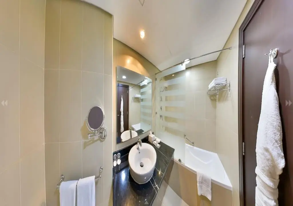 نمایی از حمام اتاق Standard King Room با وان، دوش، و سینک دستشویی مدرن.